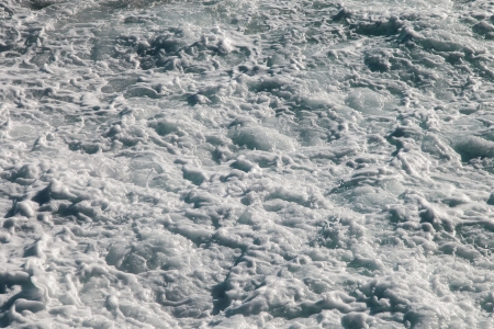 Seething sea surface covered with white foamの写真素材