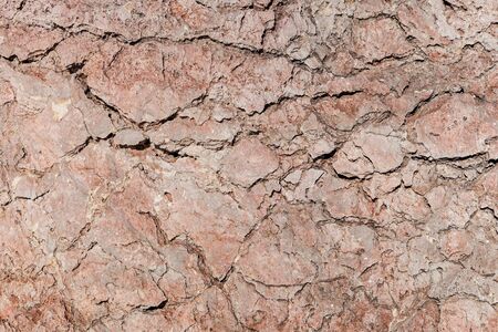 Cracked old stone illuminated bright sun as the backgroundの写真素材