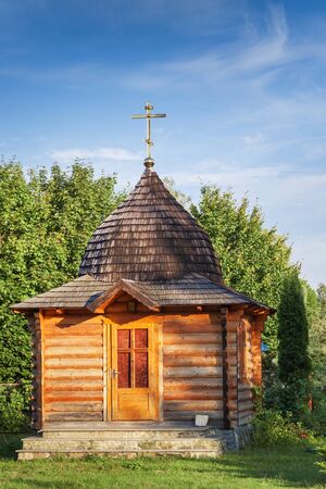 wooden chapel against the forest and blue skyの写真素材