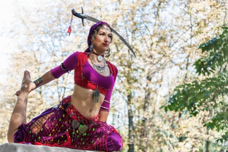 Oriental dancer with saber in the parkの写真素材