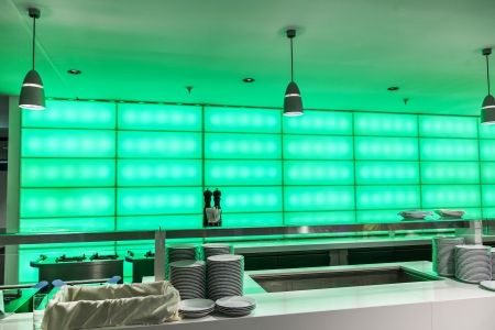 Table with dishware in the canteen with green backlightのeditorial素材