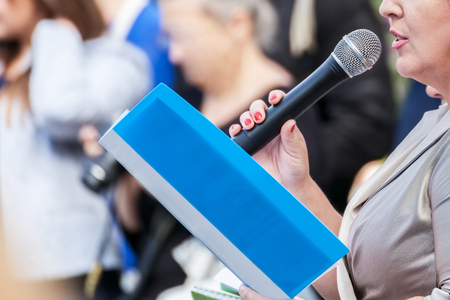 Speaker with microphone in hand at meeting closeupの写真素材