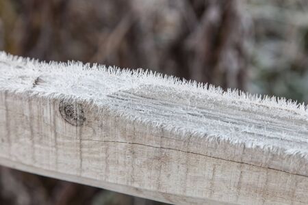 Wooden plank covered with frost closeup outdoors, abstract winter background