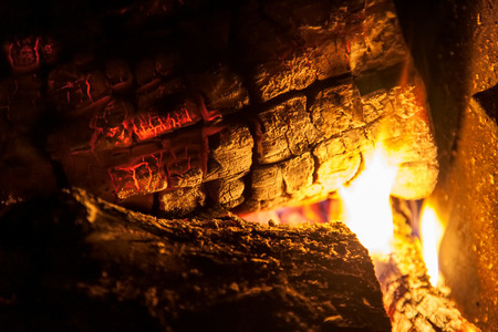 Burning firewood in the fireplace closeup, texture of fire and flameの写真素材