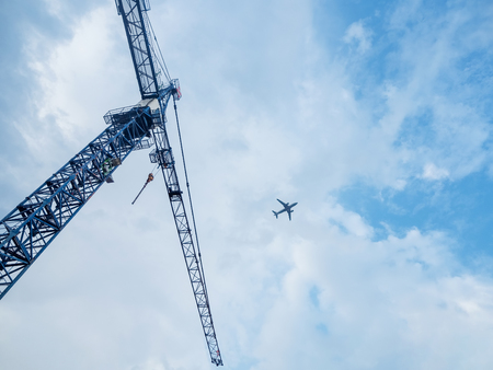 Building crane and building under construction against blue sky and flying in the plane aboveの写真素材