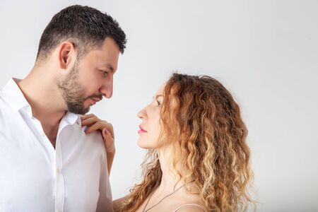 Portrait of a loving couple in studio closeup, man and woman look into each other's eyesの写真素材