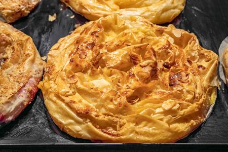 Golden brown baked puff pastry buns, filled , on baking trayの写真素材