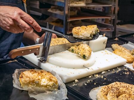 Baker cuts pastries into batch pieces for saleの写真素材