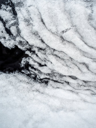 Snow cover on dark glass, abstract natural backgroundの写真素材