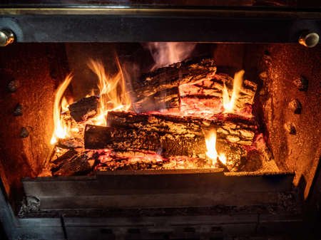 Burning firewood in the fireplace closeup