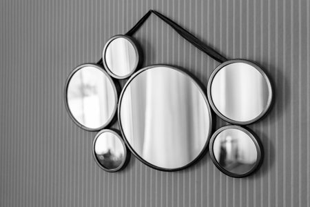 Creative mirror hangs on the wall in the room, monochrome imageの写真素材