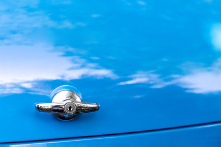 Close up of a handle for opening the tailgate of a vintage blue car