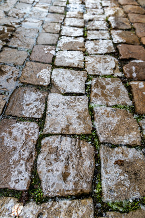 The surface of the cobblestones is covered with ice, icy conditions, black iceの写真素材
