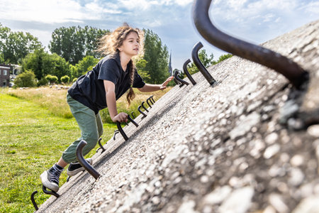 A girl climbs a concrete wall, a climbing wall outdoorsの写真素材