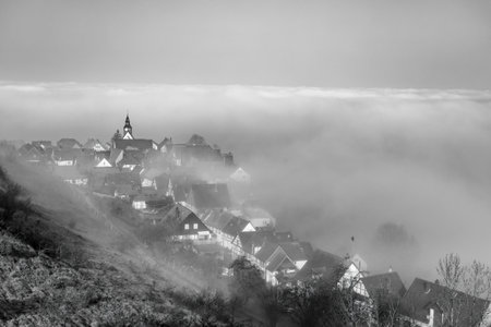 Early spring morning ancient European city shrouded in fog, black and white imageの写真素材
