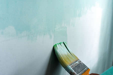 Hand painting wall with roll and brushの写真素材