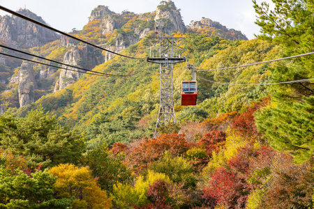 Scenic view of rocky peaks and colorful autumn forest at Daedunsan Mountain in South Korea, with a cable tower in the foreground. Photo taken on 25 October 2025の写真素材