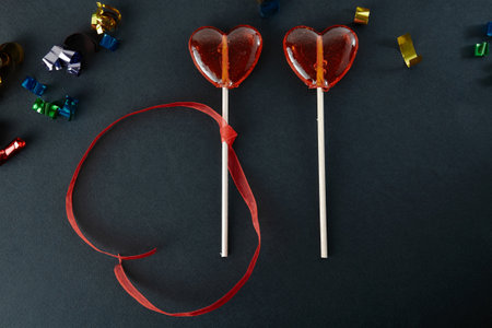 Heart-shaped sweets on a stick. Valentine's Day. Background. Candy on black background