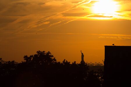 Orange sunset over the Statue of Libertyの写真素材