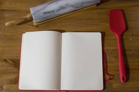Cookbook on wooden table whit utensilsの写真素材
