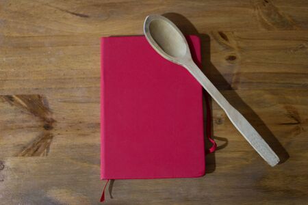 Cookbook on wooden table whit utensilsの写真素材