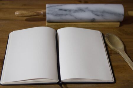 Cookbook on wooden table whit utensilsの写真素材