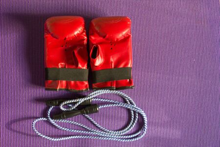 jump rope and boxing gloves on purple canvasの写真素材