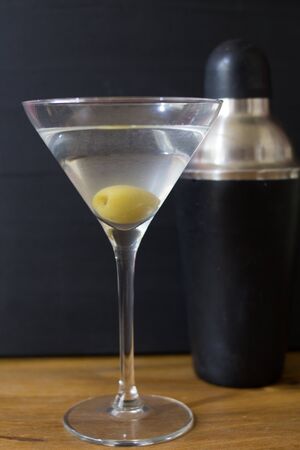 Martini glasses and cocktail shaker on wooden tableの写真素材