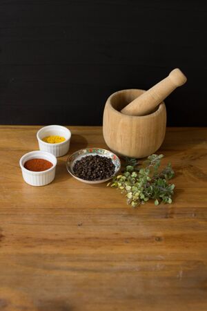 Spices and mortar on wooden tableの写真素材