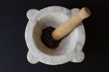 pepper in mortar on wooden tableの写真素材