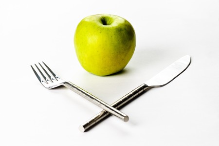 A green apple and a knife and a forkの写真素材