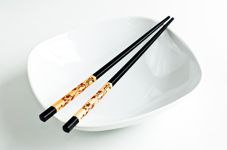 Two chop sticks and a white bowlの写真素材