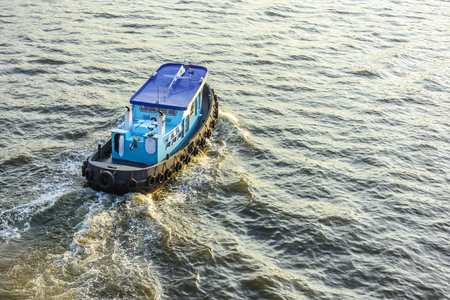 Blue tugboat sailing in calm seasの写真素材