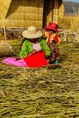 Lake Titicaca, woman knits on the bamboo floor in Uros island, Peruのeditorial素材