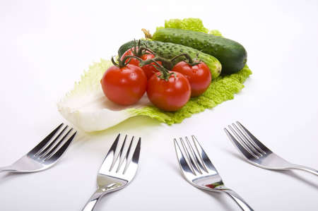 tomatoes and cucumbers and lettuce with forks の写真素材