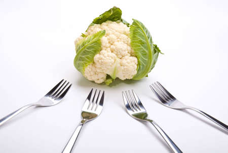 cauliflower and four forks laying on a tableの写真素材