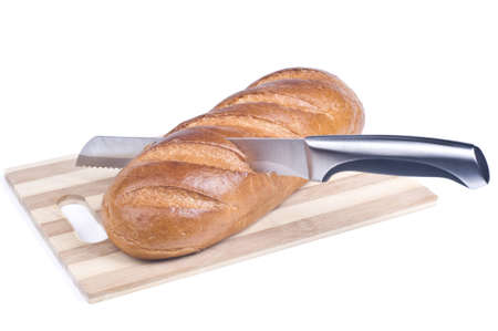 Knife cutting a long loaf isolated over whiteの写真素材