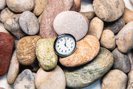Clock with time on stones for the concept of relaxation or moving forward and motivationの写真素材