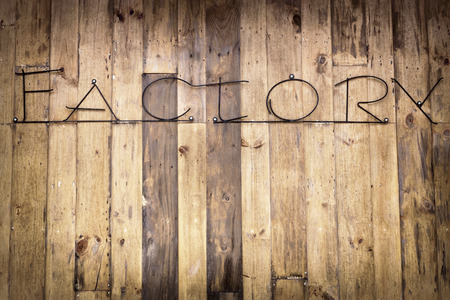 The letter of the factory word is made from steel bar on the old dirty wooden wall
