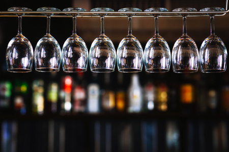 Group of wine glasses hanging  upside down above a bar rack in pub & restaurantの写真素材