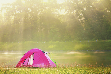 The pink tent of tourists  at the edge of the lake in the morning atmosphereの写真素材