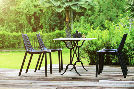 Modern designed outdoor furniture set relax corner table and chairs on wooden floor in the gardenの写真素材