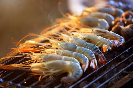 Fresh grilled river shrimp on the grill with flames selective focusの写真素材