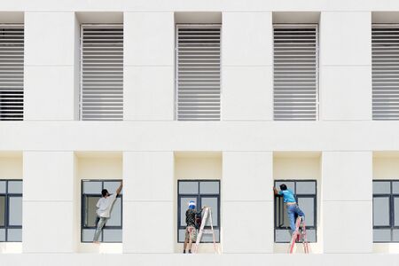 the worker installing window part at the office building
