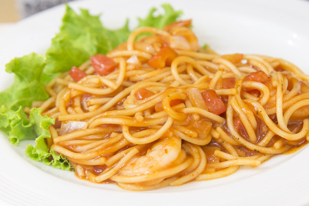 the spaghetti tomatoes sauce with shrimp on the white dish serve with saladの写真素材