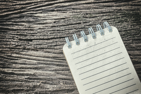 the note book with the wooden background in old effect