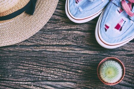 the flat lay of the wooden background with the hat ,shoe and cactus plant in vintage styleの写真素材