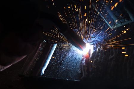 the welding spark light in close-up scene,the torch of welging machine with the spark light in blue