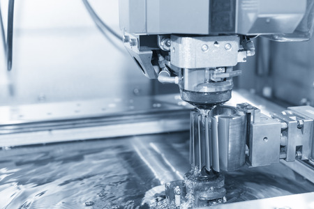 Abstract scene of close-up of the wire - EDM CNC machine while cutting the sample work pieces in light blue tone and controller panelの写真素材