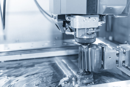 Abstract scene of close-up of the wire - EDM CNC machine while cutting the sample work pieces in light blue tone and controller panel